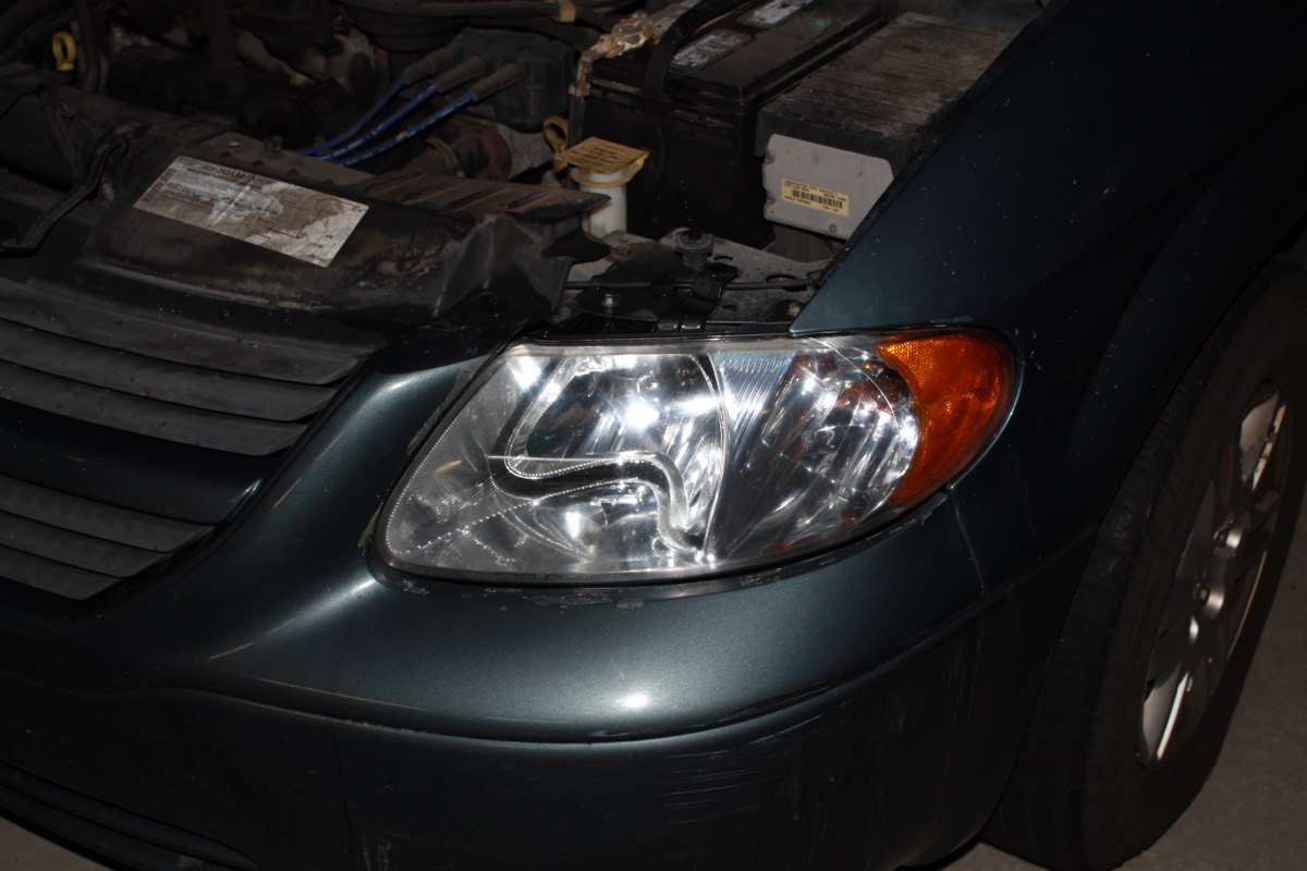The same Dodge Grand Caravan headlight after restoration, fully clear with visible reflector detail