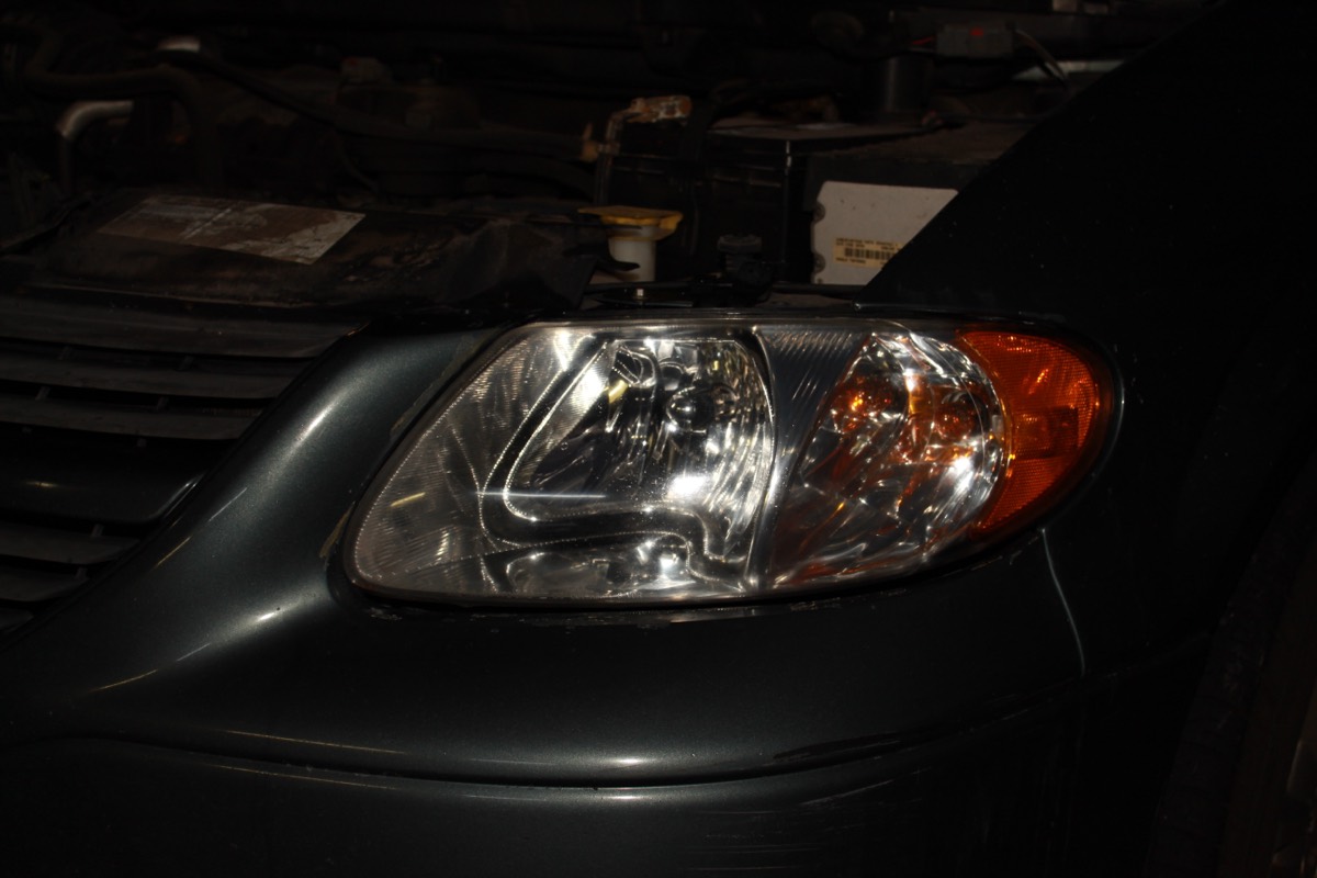 The same minivan headlight after restoration, clear enough to see the bulb and amber turn signal inside